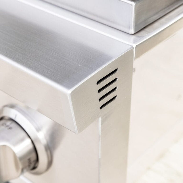 Close-up of stainless steel vented corner panel showing sleek brushed metal finish and control knob detail.