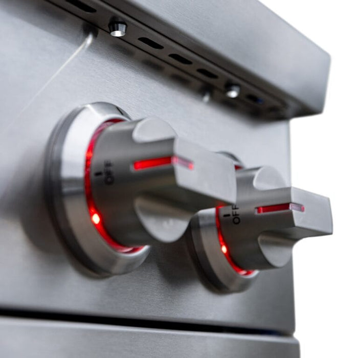 Close-up of stainless steel control knobs illuminated with red LED lighting on a modern outdoor grill for heat control.