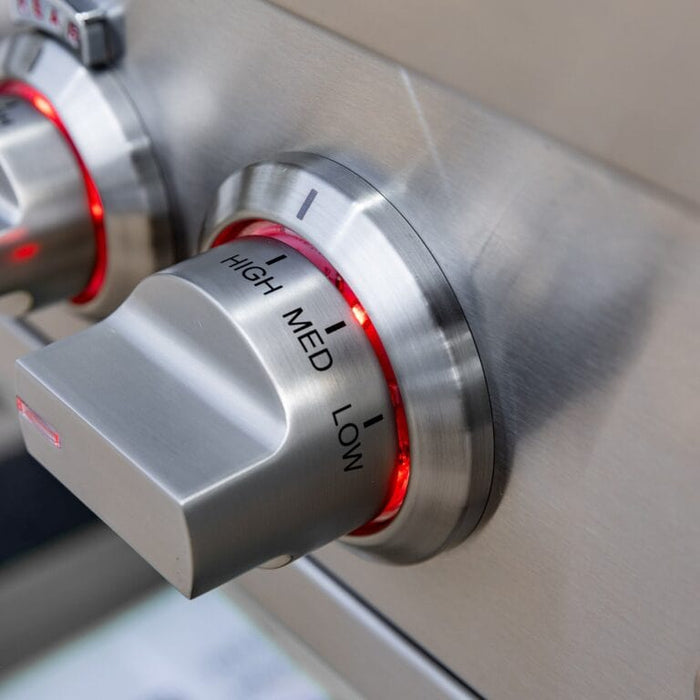 Close-up of stainless steel grill control knob labeled high, medium, and low with red LED lighting.