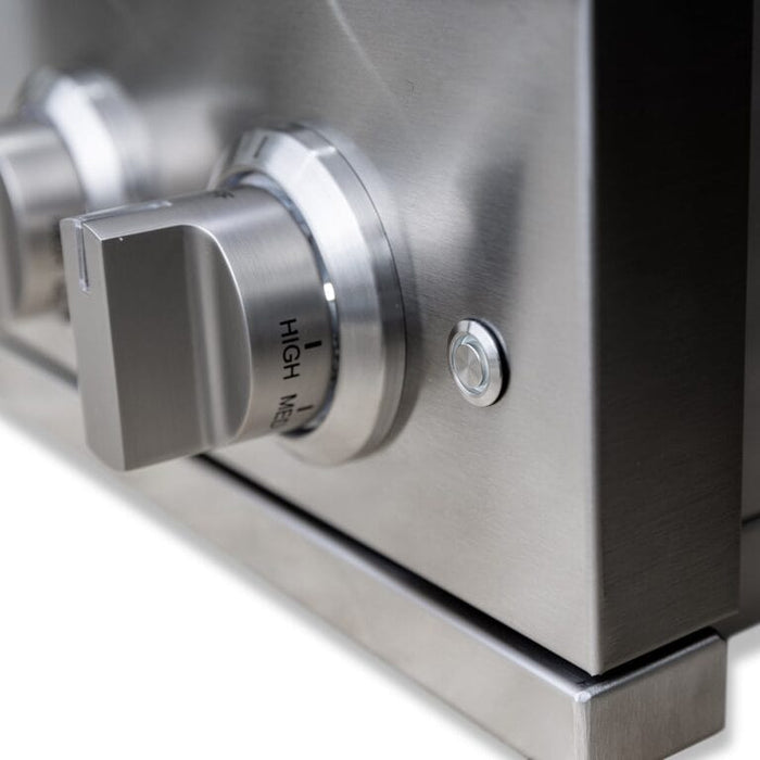 Close-up of stainless steel control knob and ignition button on a modern outdoor grill for precise heat adjustment.