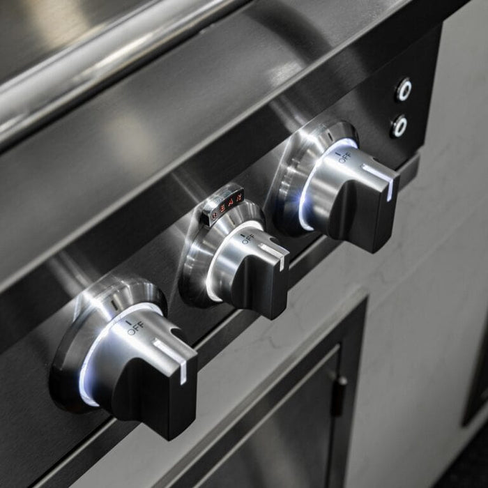 Close-up of stainless steel grill control knobs illuminated with blue LED lighting on front panel.