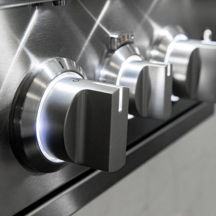 Close-up of stainless steel grill control knobs illuminated with white LED lighting.