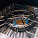 Close-up of a stainless steel outdoor burner with a brass burner and blue flame, surrounded by polished, sturdy grates.