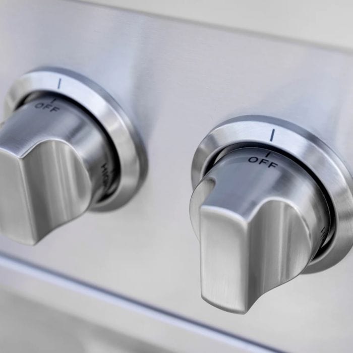 Close-up of stainless steel control knobs on a grill or side burner, displaying precision markings and a sleek modern finish.
