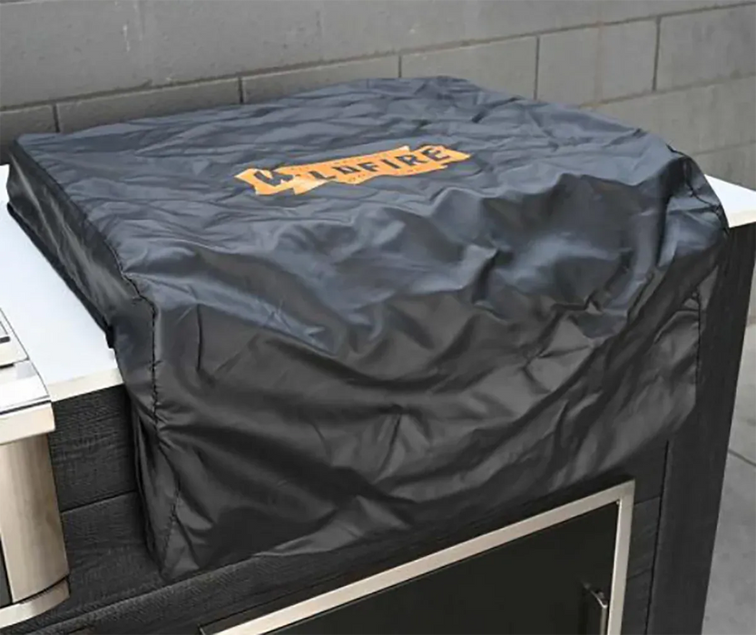 Black outdoor grill cover folded over a grill’s top, protecting it from weather and outdoor elements.