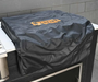 Black outdoor grill cover folded over a grill’s top, protecting it from weather and outdoor elements.