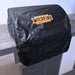 Alt text: Black outdoor grill cover draped over a stainless steel grill hood, protecting it from weather and elements.