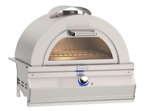 Stainless steel outdoor pizza oven with domed top, front glass window, interior cooking rack, and control knob with blue light.