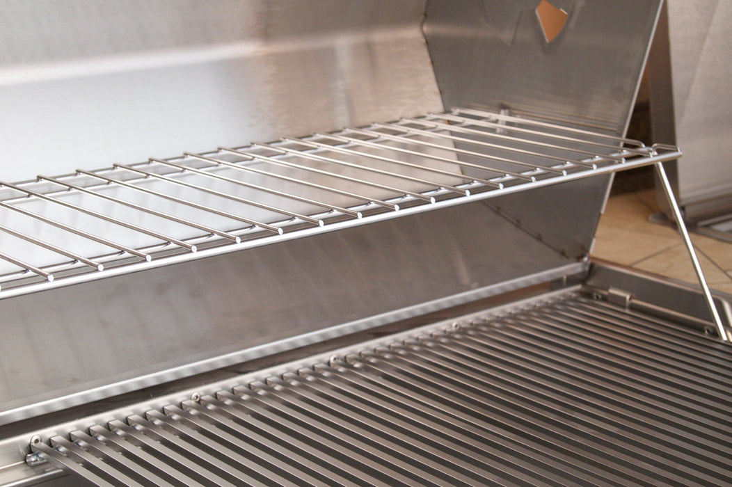 Interior view of stainless steel grill showing main cooking grate and elevated warming rack for versatile grilling options.