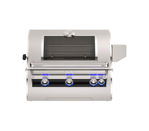Built-in stainless steel gas grill with glass viewing window, analog thermometer, and blue LED-lit knobs for luxury outdoor cooking.