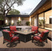 A square fire pit table with a glass enclosure, surrounded by red cushioned chairs on a patio with a pool in the background.