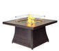 A square outdoor fire pit table with a glass enclosure, showing a lit fire and decorative rocks.