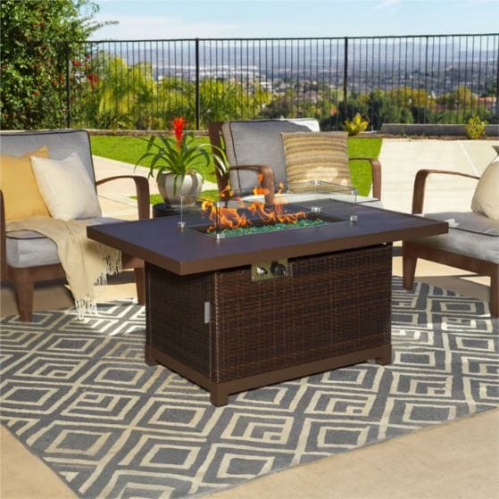 Outdoor patio setup featuring a rectangular fire pit table with a wicker base, surrounded by cozy seating and a geometric-patterned rug.