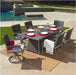 Outdoor dining set featuring a rectangular fire pit table, six cushioned chairs (two swivel), set on a patio near a pool for elegant gatherings.