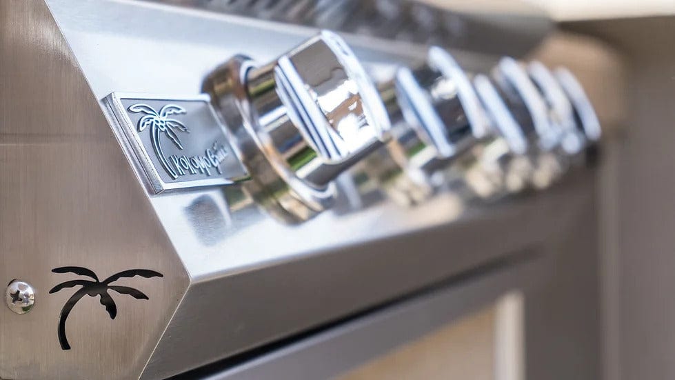 Angled view of stainless steel built-in gas grill with five burners, back burner, polished hood, control knobs, and KoKoMo Grills logo