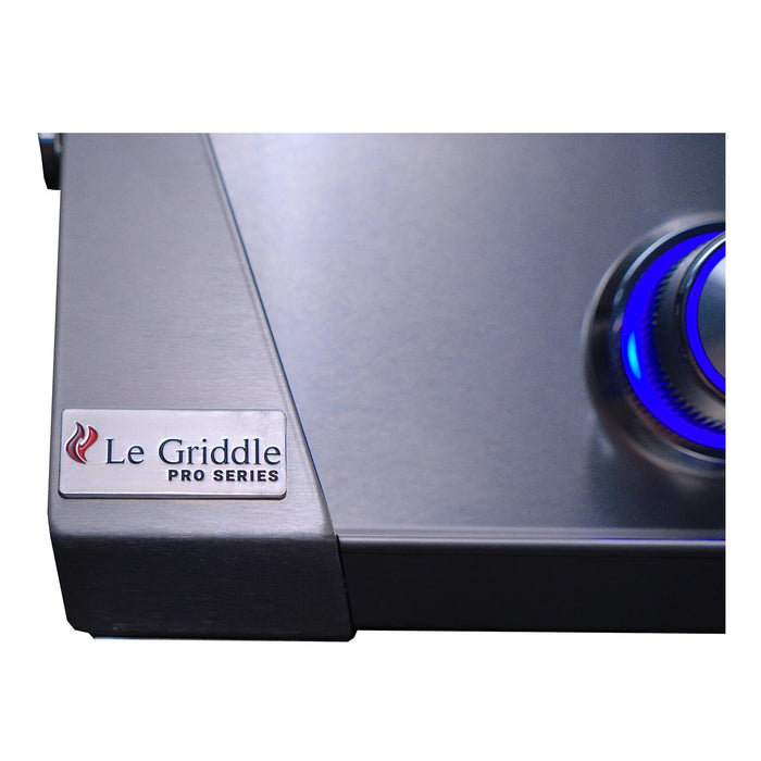 Close-up of stainless steel griddle surface with blue illuminated control knob and brushed metal construction.