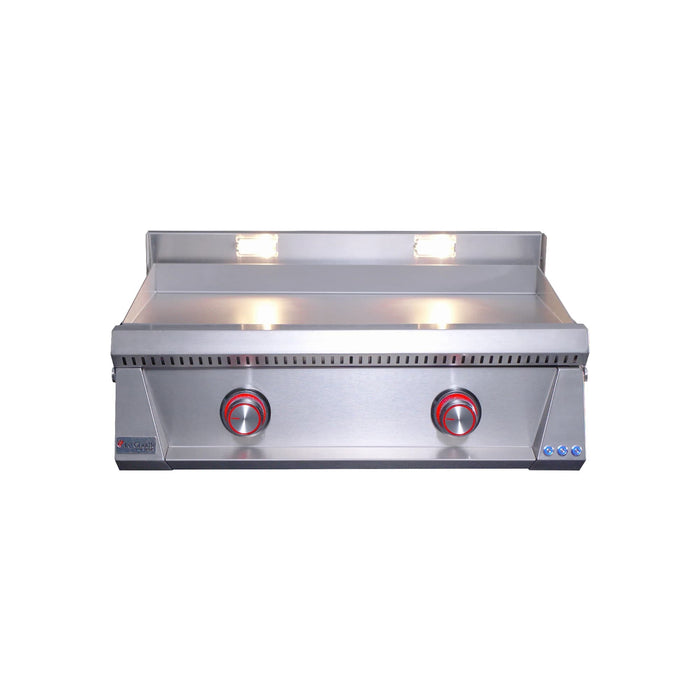 Stainless steel gas griddle with red illuminated control knobs and dual cooking lights shining over the flat-top surface.