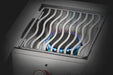 Close-up of a stainless steel outdoor burner with wavy grill grates, blue flame visible beneath for precise and efficient cooking.