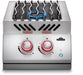 Stainless steel double burner with wavy grill grates, visible blue flame, red-lit control knobs, and push-button ignition for cooking.