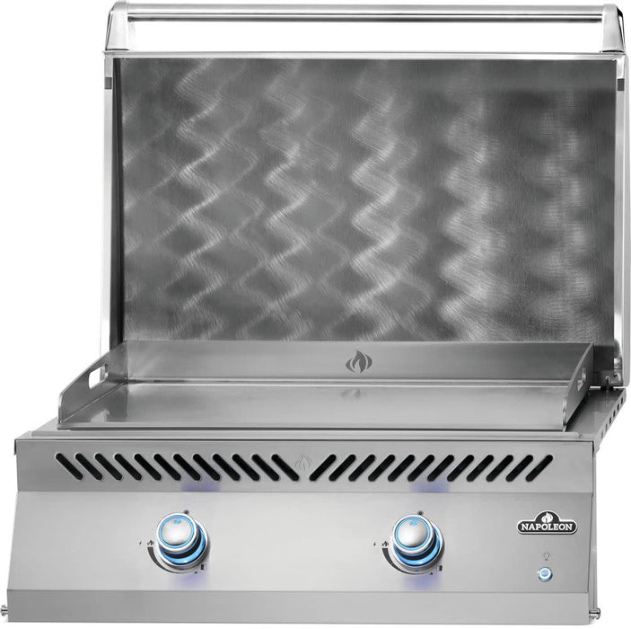 Stainless steel outdoor griddle with a raised lid, textured backsplash, dual blue-lit control knobs, and a vented design for cooking.