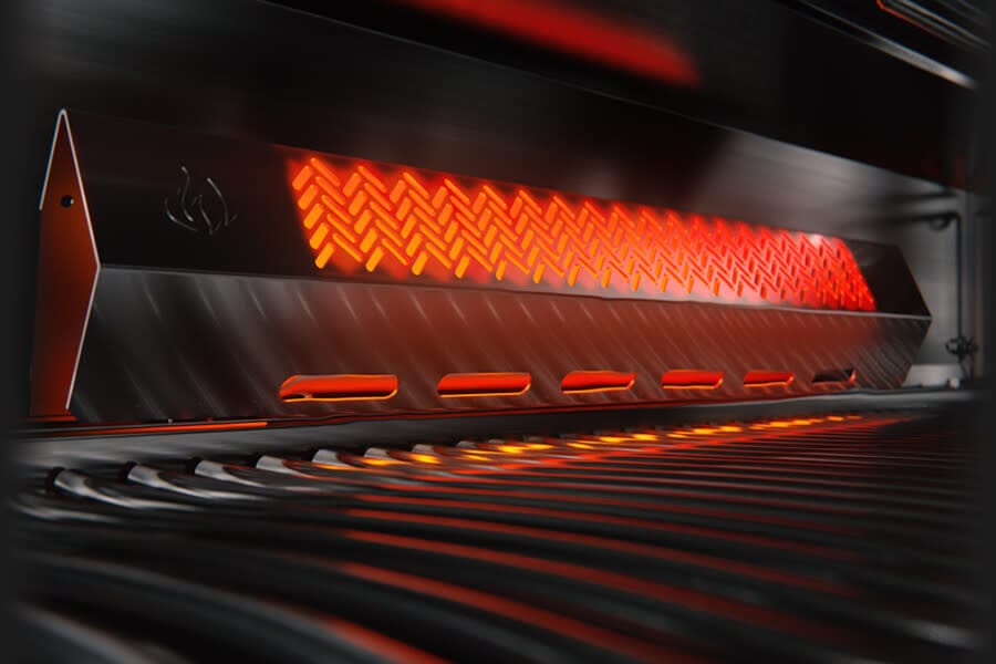 Close-up of an infrared burner inside a stainless steel gas grill, glowing red for high-intensity heat and efficient cooking.