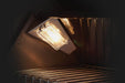 Close-up of an interior light inside a gas grill, illuminating the cooking area with stainless steel grates and a reflective surface.