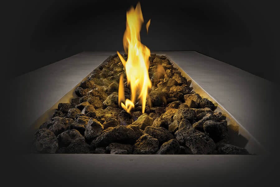 Close-up view of a rectangular fire pit with glowing flames and lava rocks, set against a dark background for dramatic effect.