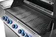 Close-up view of stainless steel grill grates with wave-like design, control knobs illuminated in blue, and a burner in the background.