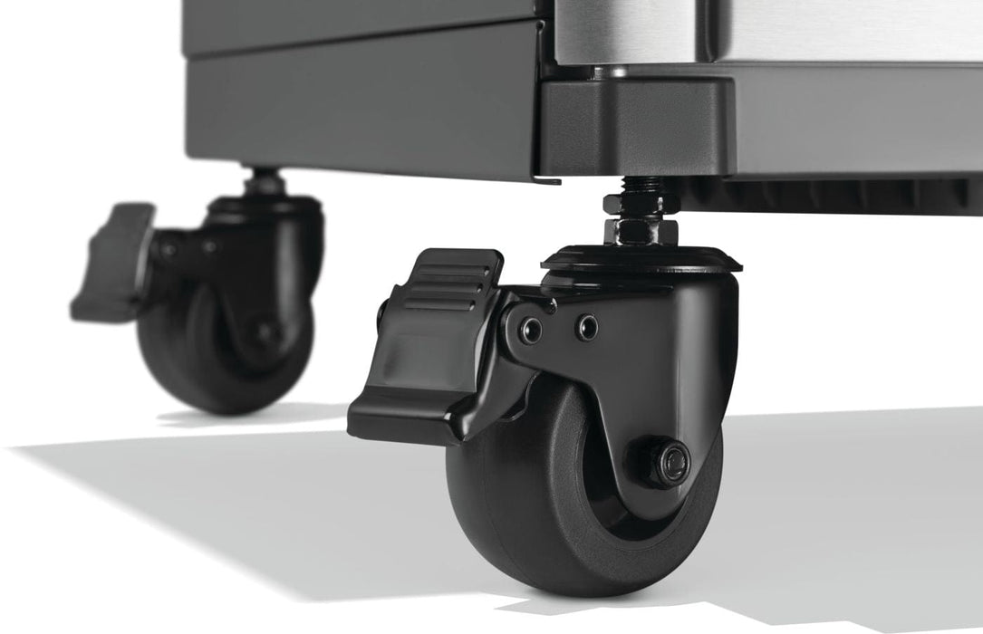 Close-up of black caster wheels with locking mechanisms, attached to the base of a metal appliance for mobility and stability.