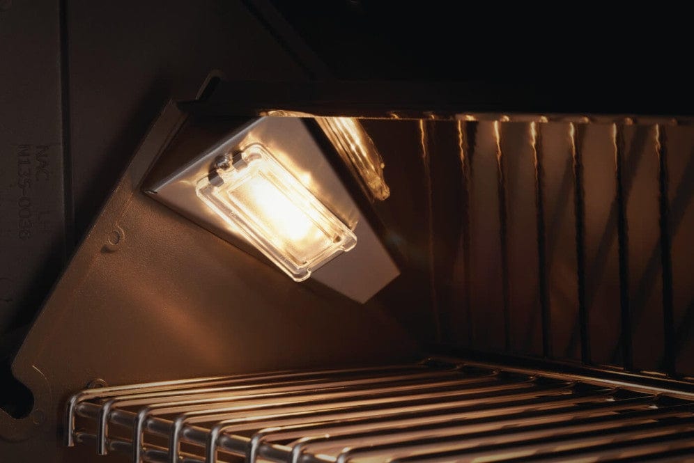 Close-up of an illuminated grill interior with built-in lighting, highlighting stainless steel cooking grates