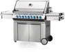 Angled view of stainless steel gas grill with multiple burners, blue LED control knobs, side shelves, cabinet storage, and sleek modern design