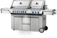 Angled view of a stainless steel outdoor grill with dual lids, blue-lit control knobs, side burners, storage cabinets, and a sleek, durable design