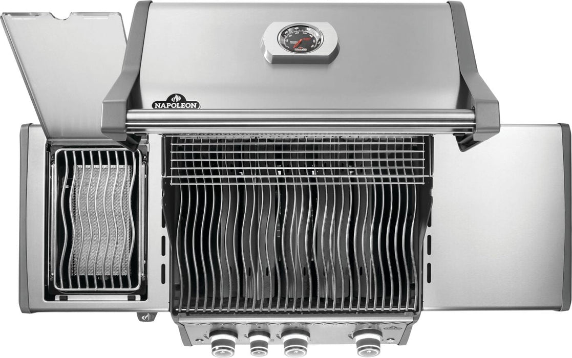 Top view of an open grill with wave-shaped grates, a side burner with a raised lid, and a built-in thermometer on the hood.