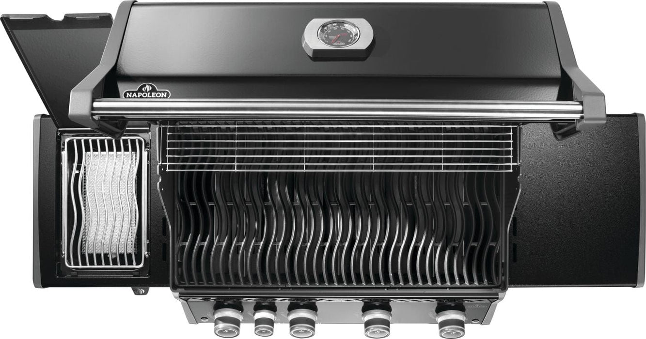 Top-down view of an open grill showing cooking grids, warming rack, side burner with lid open, and control knobs at the bottom.