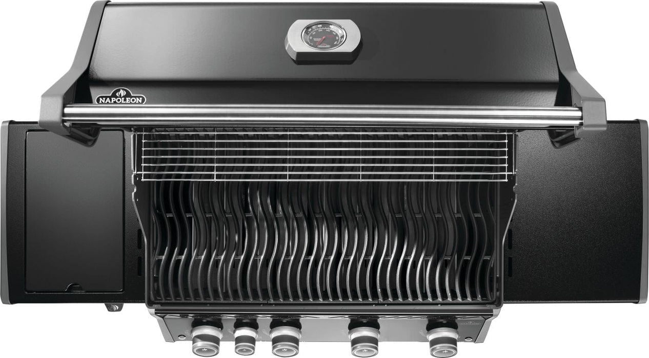 Top view of an open grill with curved cooking grids, warming rack, closed side burner on the left, and control knobs at the bottom.