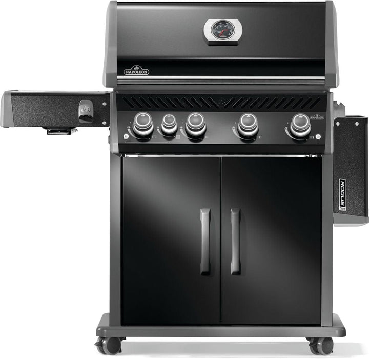 Black grill with four control knobs, double cabinet doors, side burner on the left, and utensil hooks on the right side panel.