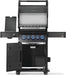 Black freestanding grill with open hood revealing cooking grates, side shelves, illuminated knobs, and a storage cabinet with open doors.