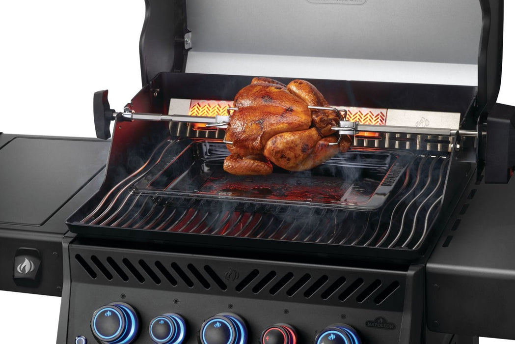 Chicken roasting on a rotisserie inside a grill with glowing burners and smoke rising, surrounded by a modern control panel.