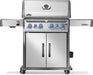 Stainless steel grill with illuminated control knobs, dual doors at the base, and foldable side shelves on a wheeled base.