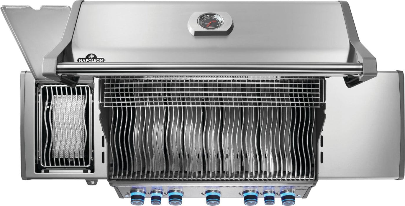 Top view of an open stainless steel grill with blue-lit control knobs, cooking grates, warming rack, and a side burner lid open.