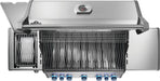 Top view of an open stainless steel grill with blue-lit control knobs, cooking grates, warming rack, and a side burner lid open.