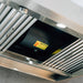 Close-up of stainless steel vent hood underside showing fan motor, LED light, and removable grease filters.