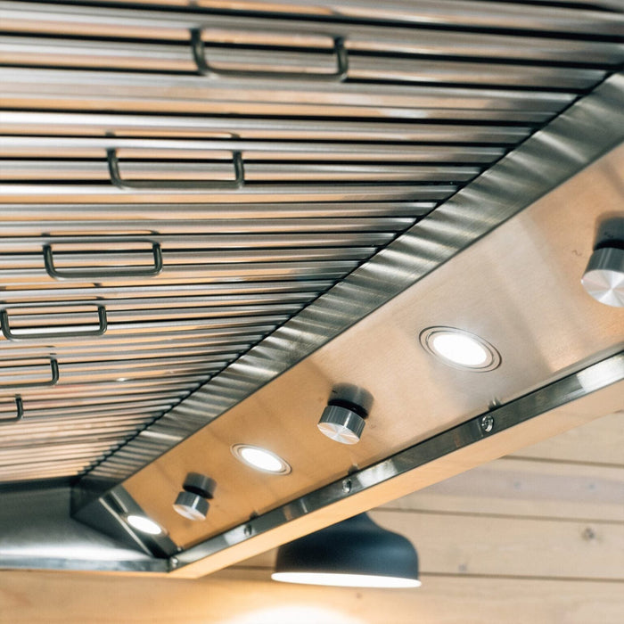 Close-up of stainless steel outdoor vent hood showing LED lights and grease filter panels.
