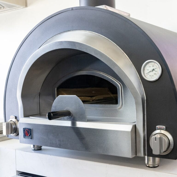 Stainless steel outdoor pizza oven with built-in thermometer, control knobs, and partially open door handle.
