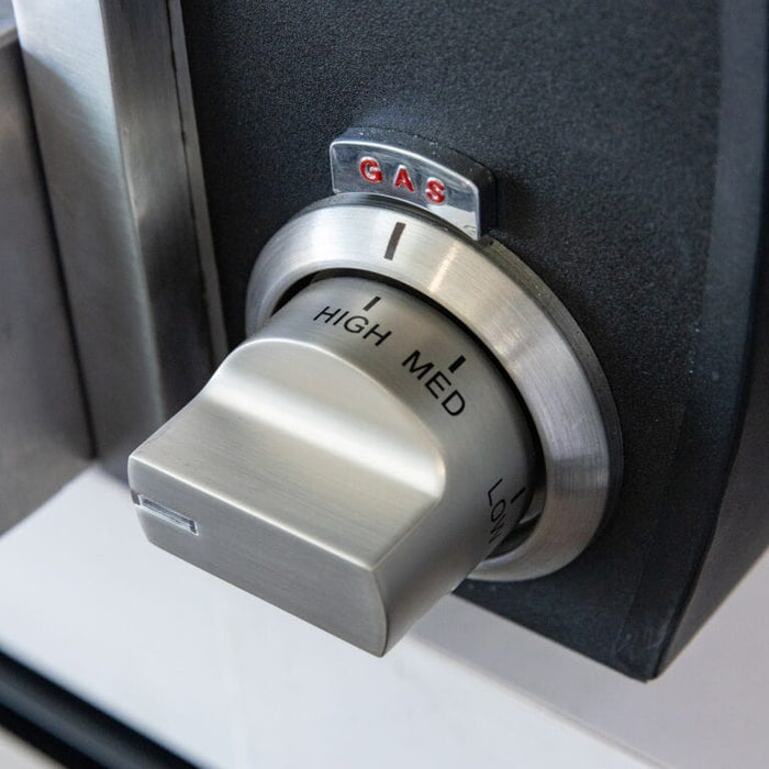 Close-up of stainless steel gas control knob labeled high, medium, and low on an outdoor pizza oven.