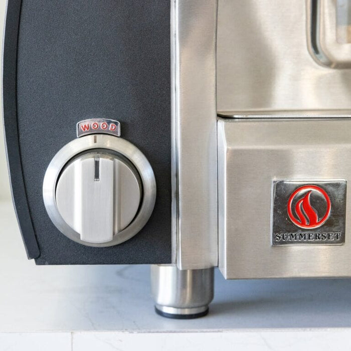 Close-up of stainless steel outdoor pizza oven control knob labeled wood with polished metal finish.