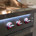 Close-up of stainless steel grill control panel with illuminated red LED knobs and side cooking area.