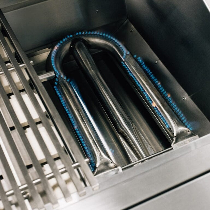Close-up of stainless steel grill burner with blue flame evenly distributed beneath cooking grates.
