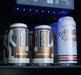 Close-up of beverage cans arranged under blue LED lighting inside a refrigerator with a control panel visible above.