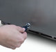 Hand inserting a key into a lock mechanism on a stainless steel panel with vented grille, demonstrating secure access functionality.